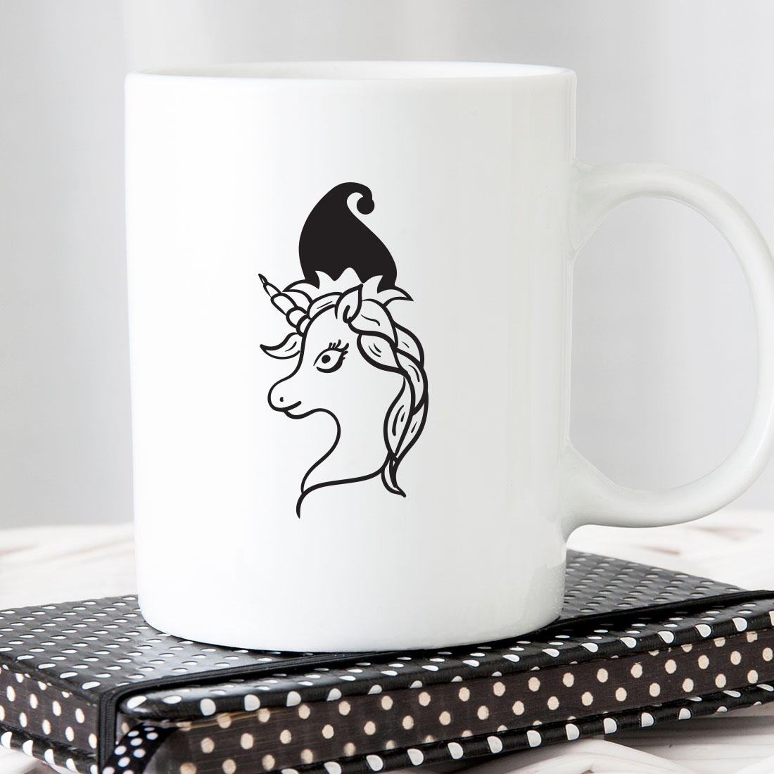 Coffee mug with a black and white picture of a unicorn on it.