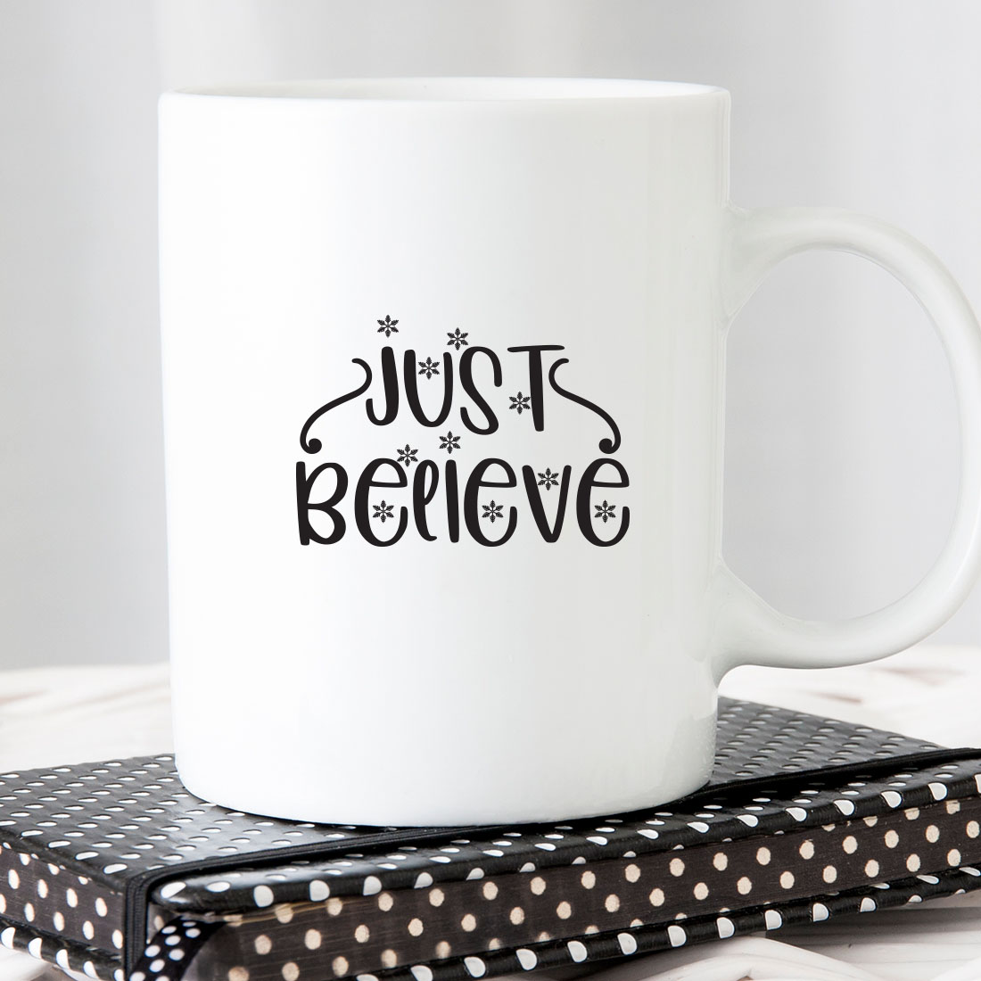 White coffee mug sitting on top of a book.