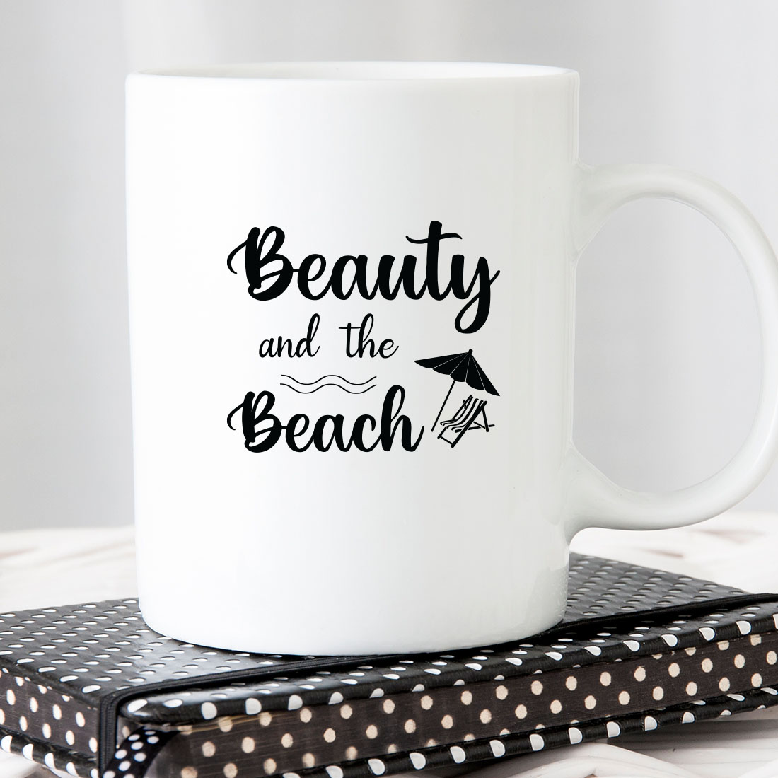 White coffee mug with the words beauty and the beach on it.