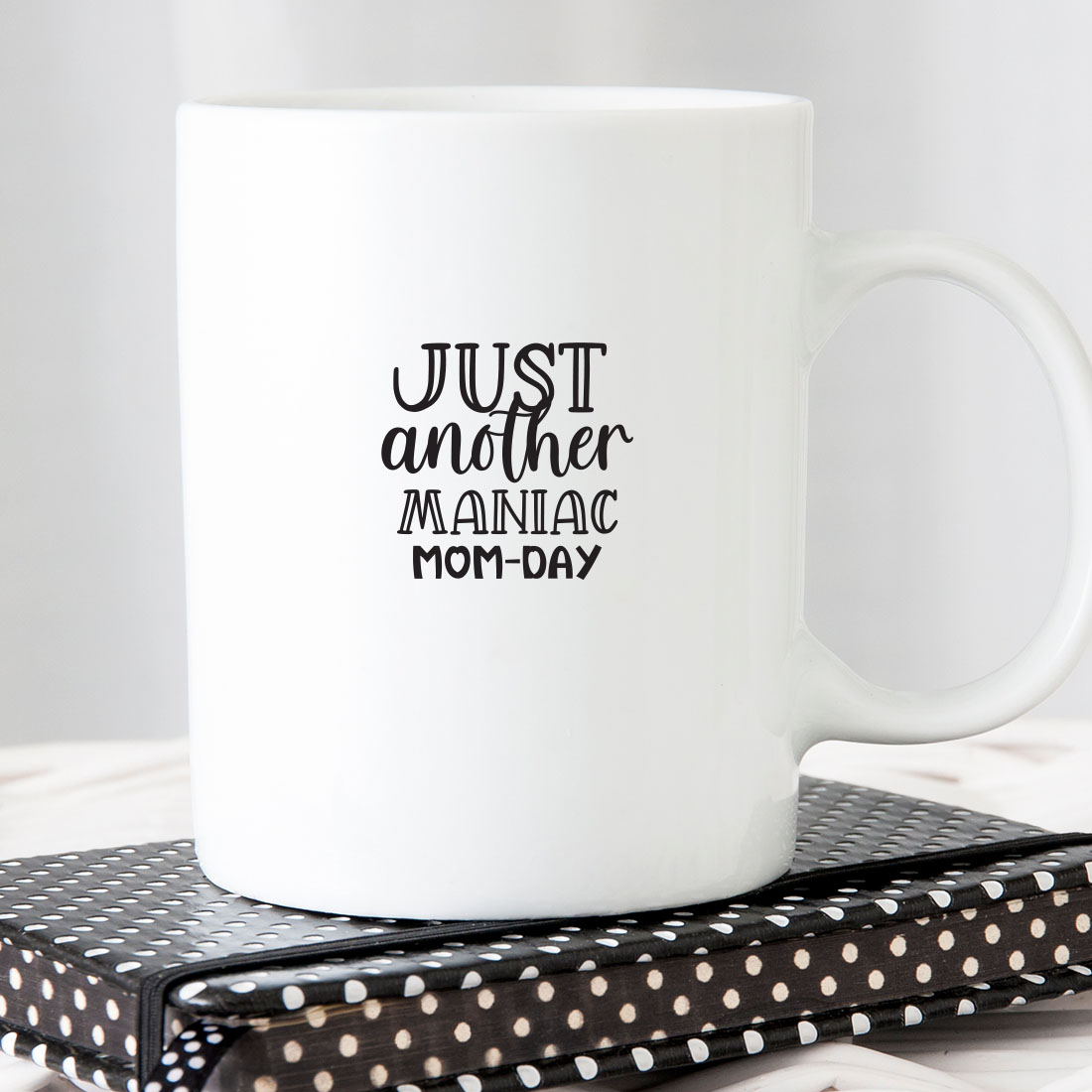 White coffee mug sitting on top of a book.