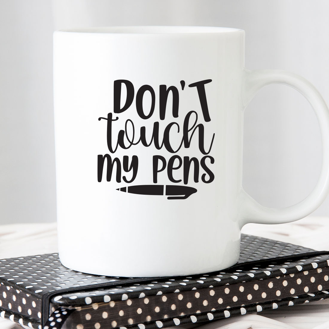 White coffee mug that says don't touch my pens.