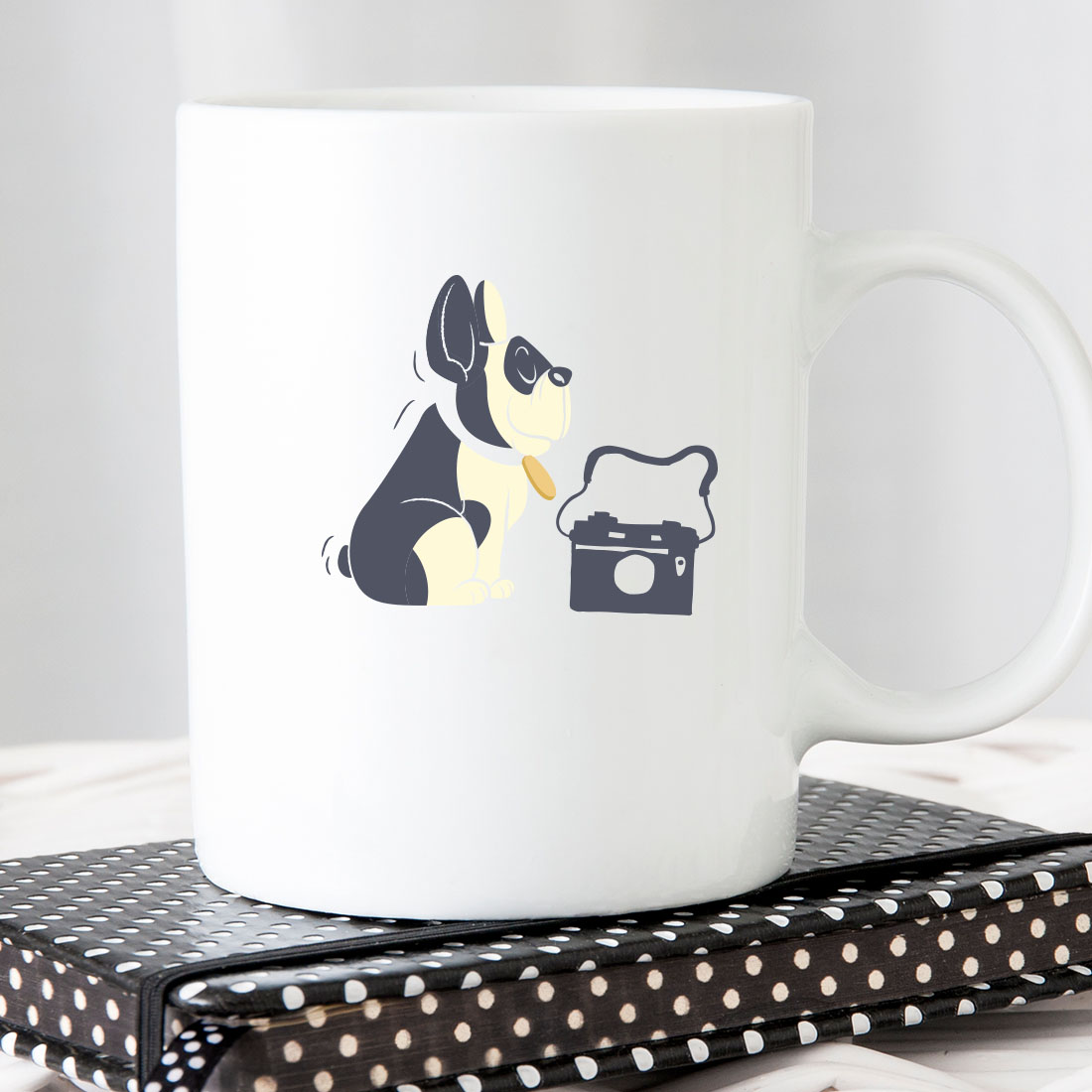 White coffee mug with a black and white dog on it.