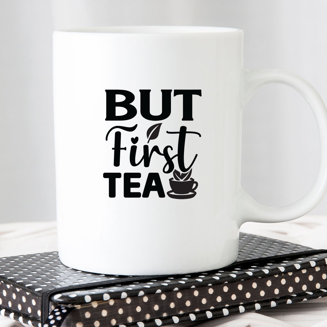 White coffee mug sitting on top of a book.