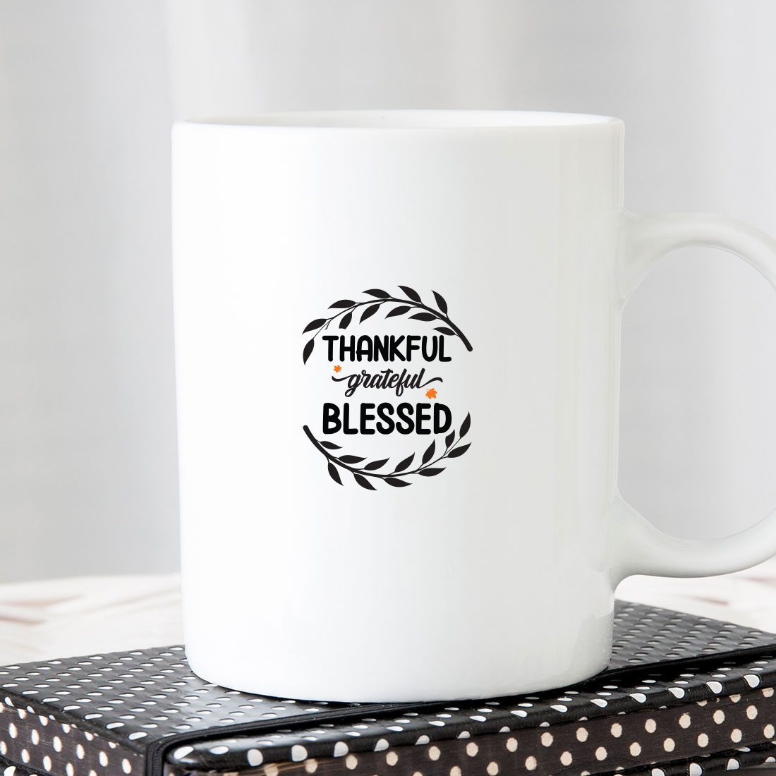 White coffee mug sitting on top of a stack of books.