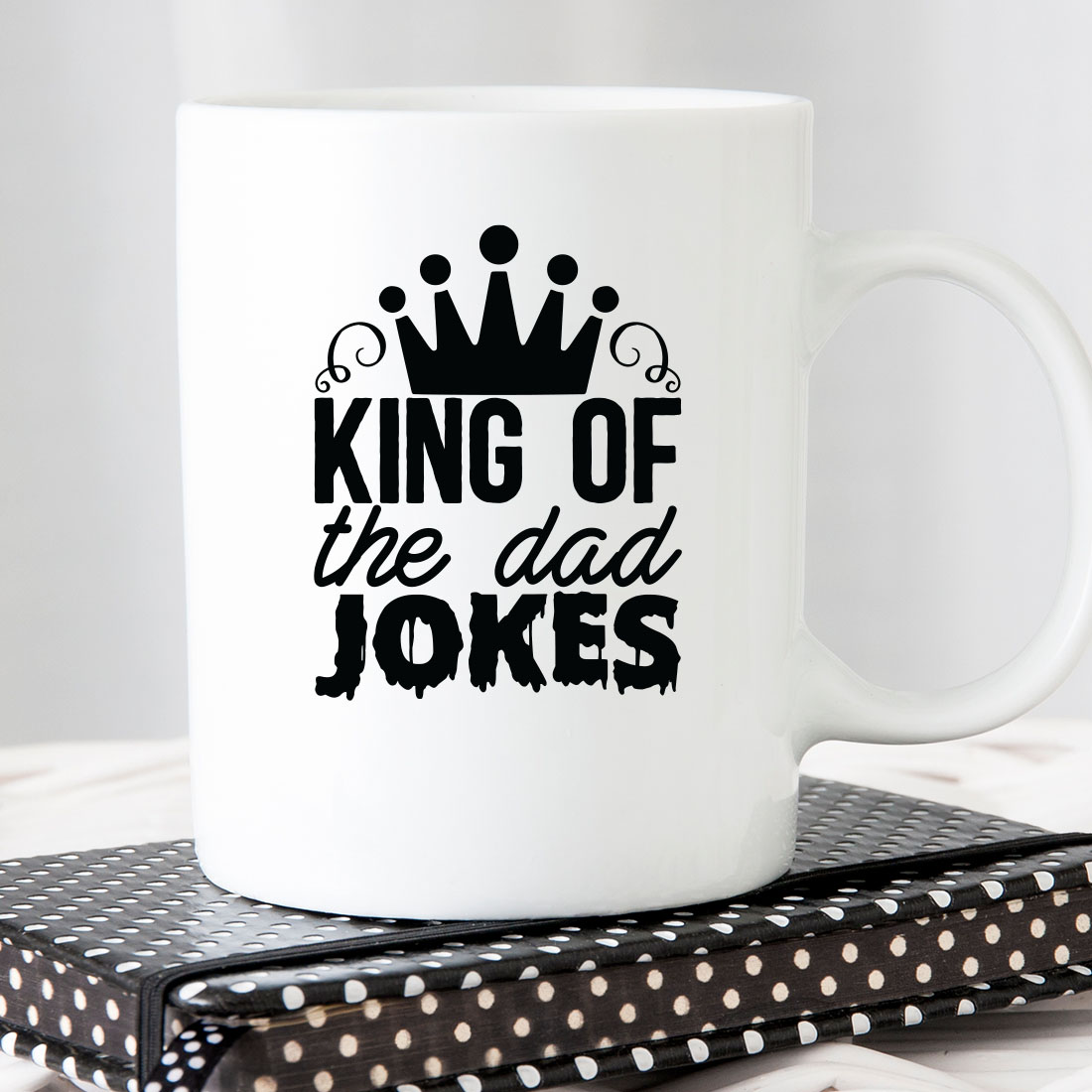 White coffee mug with the words king of the dad jokes on it.