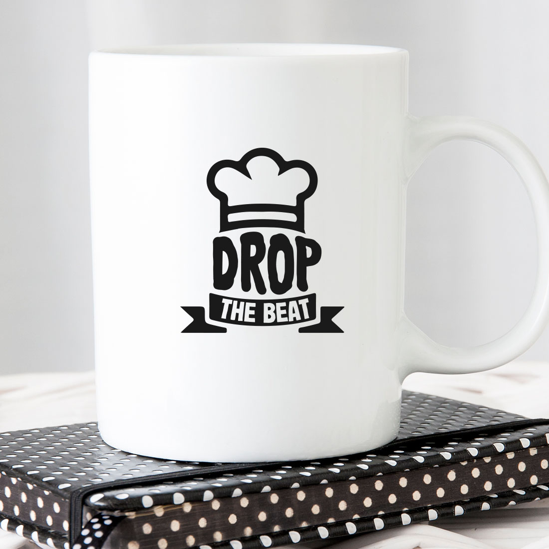 White coffee mug with the words drop the beat on it.