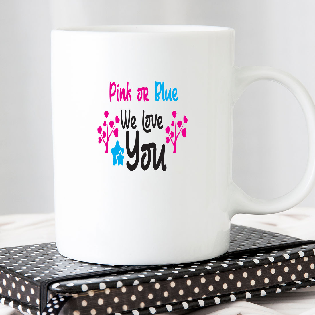 White coffee mug that says pink or blue.