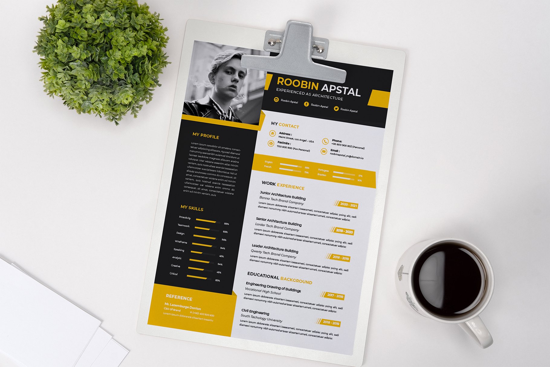 Yellow and black resume on a clipboard next to a cup of coffee.