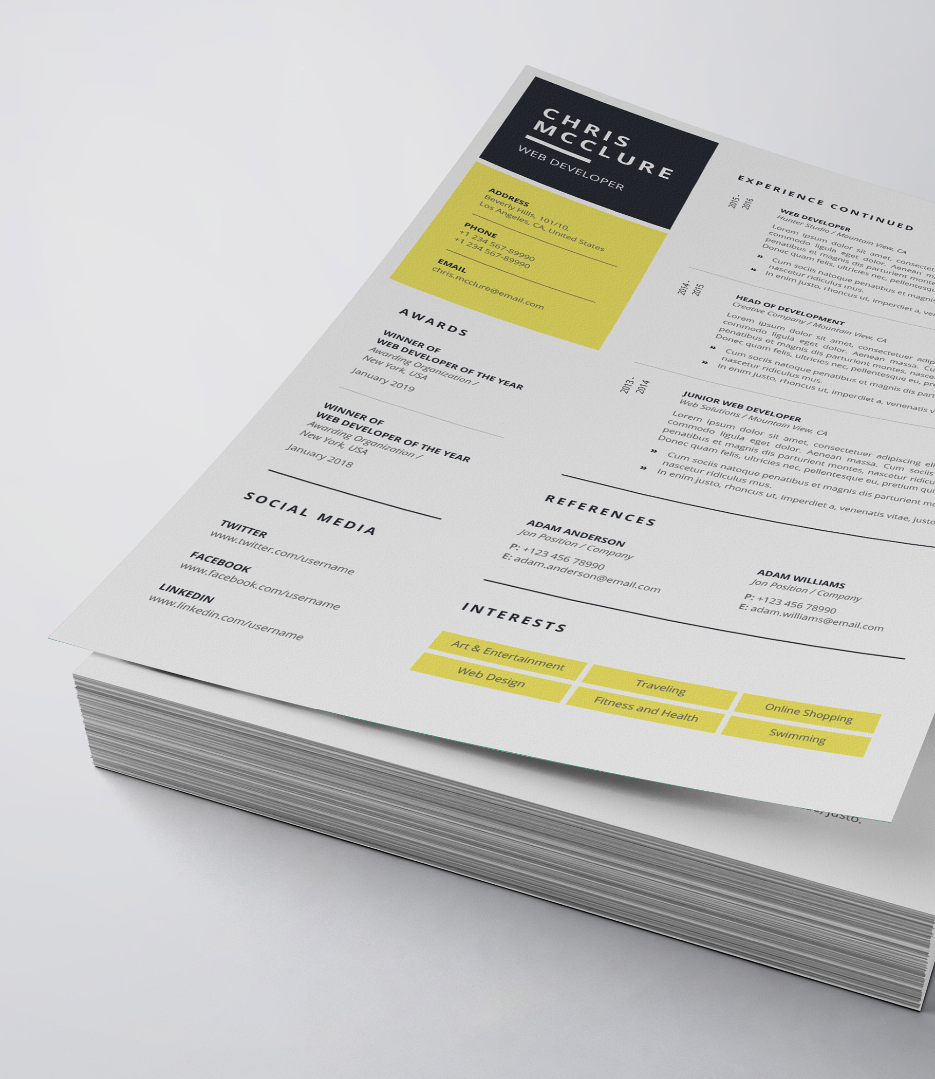 White and yellow resume on top of a stack of papers.