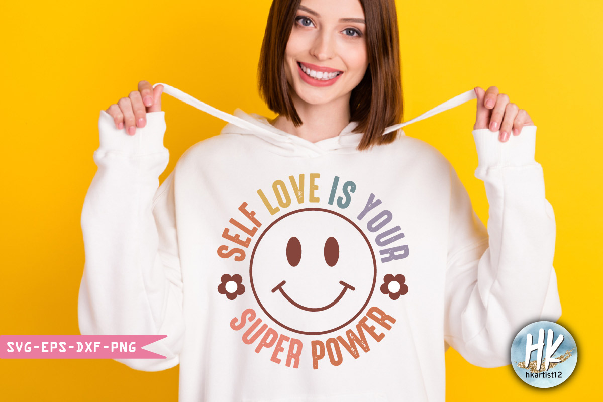 Woman holding a white hoodie with a smiley face on it.