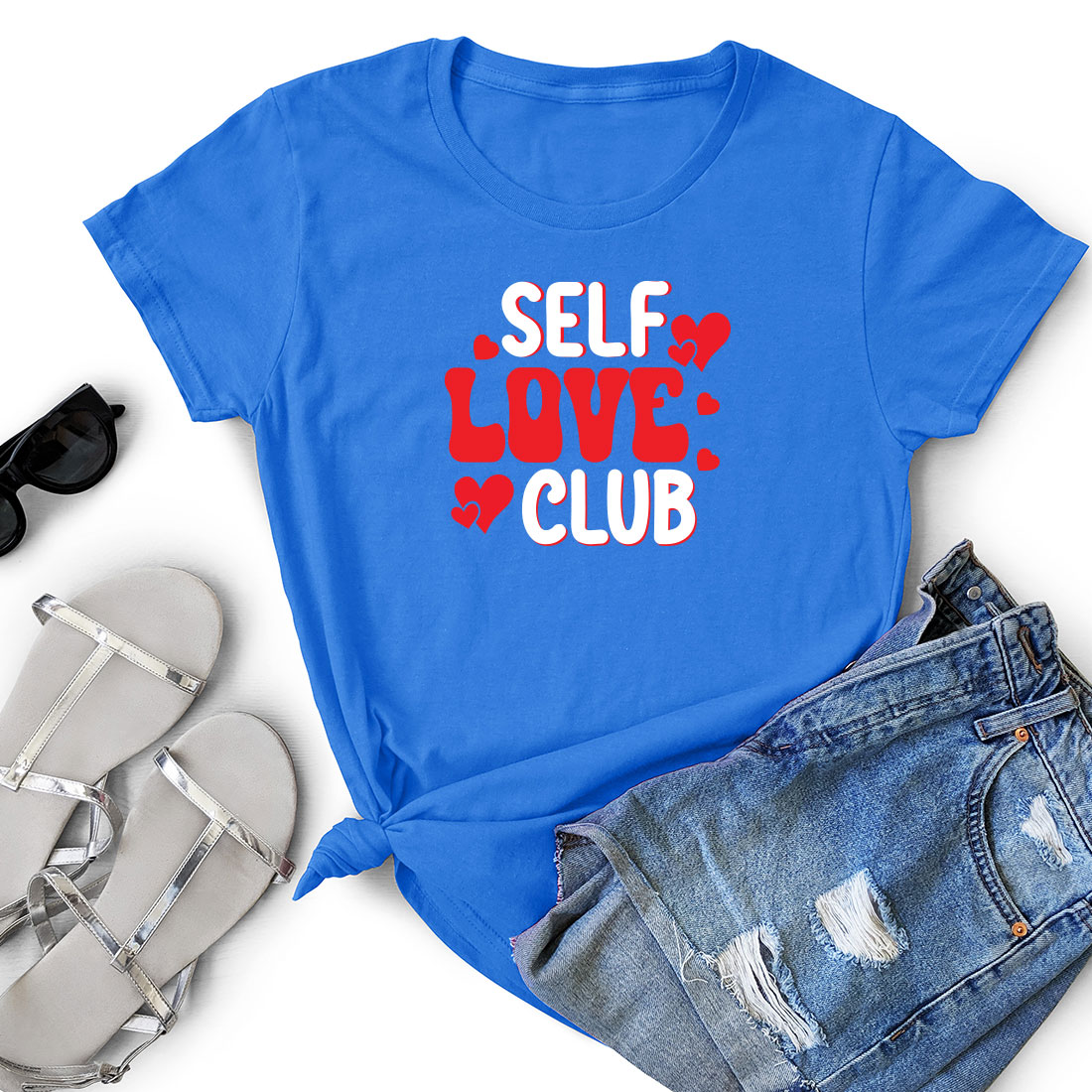 T - shirt that says self love club next to a pair of shorts.