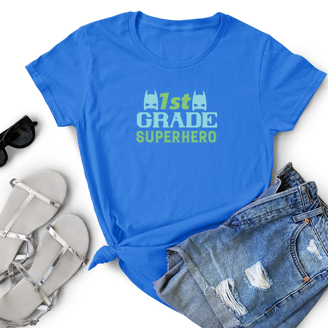 T - shirt that says 1st grade superhero next to a pair of shorts.