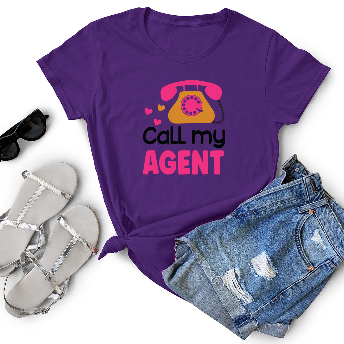 Purple t - shirt that says call my agent next to a pair of shorts.