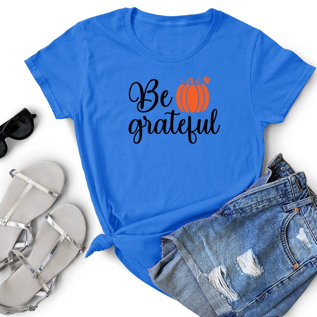 T - shirt that says be grateful next to a pair of shorts.