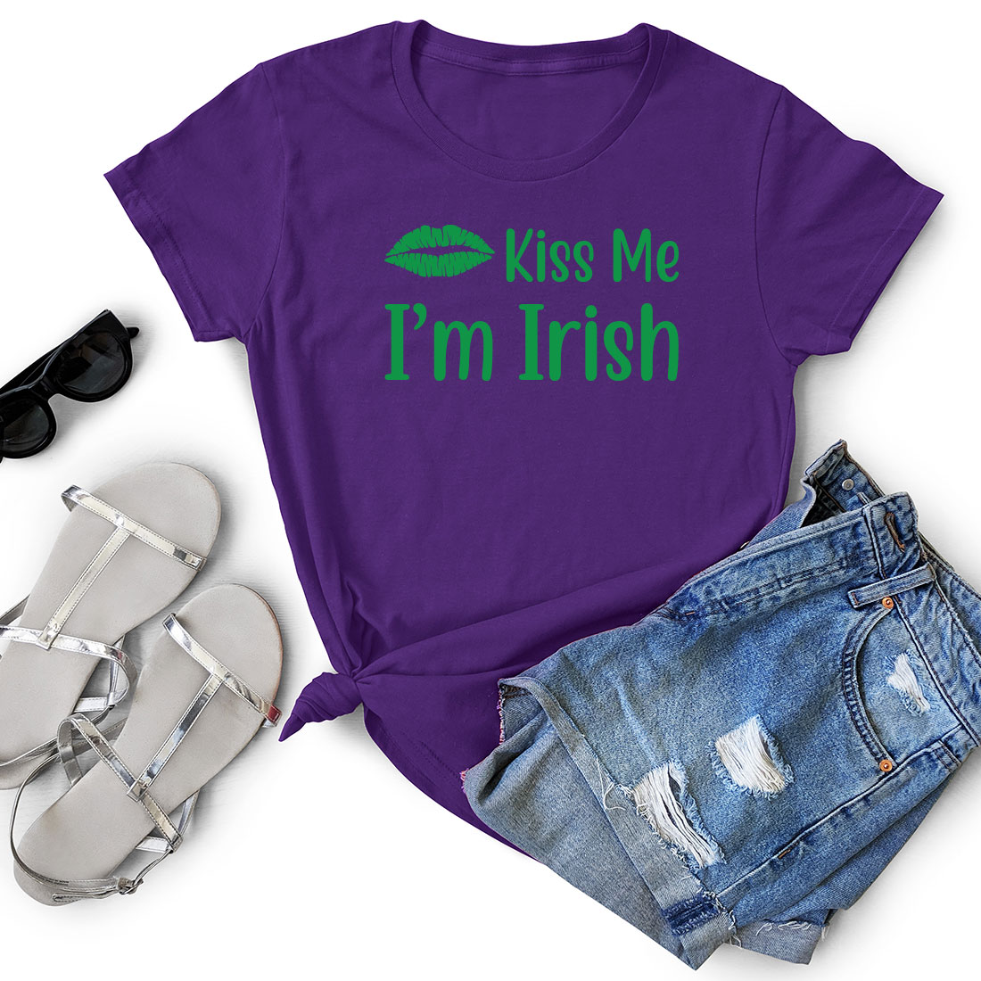 Purple shirt that says kiss me i'm irish next to a pair of.