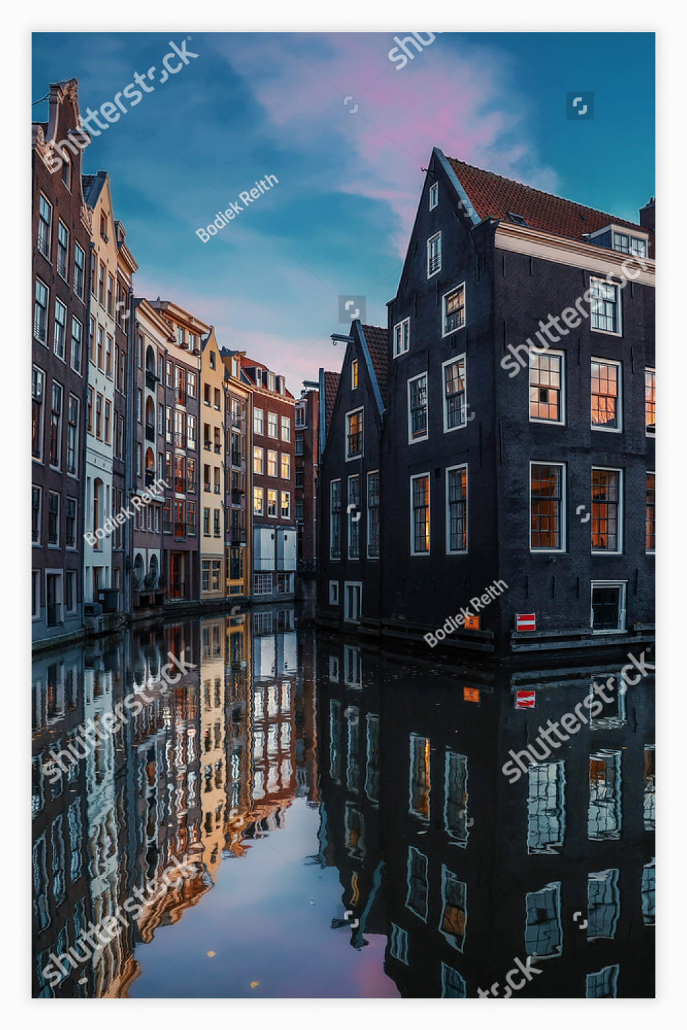 Canal in a city with buildings reflecting in the water.