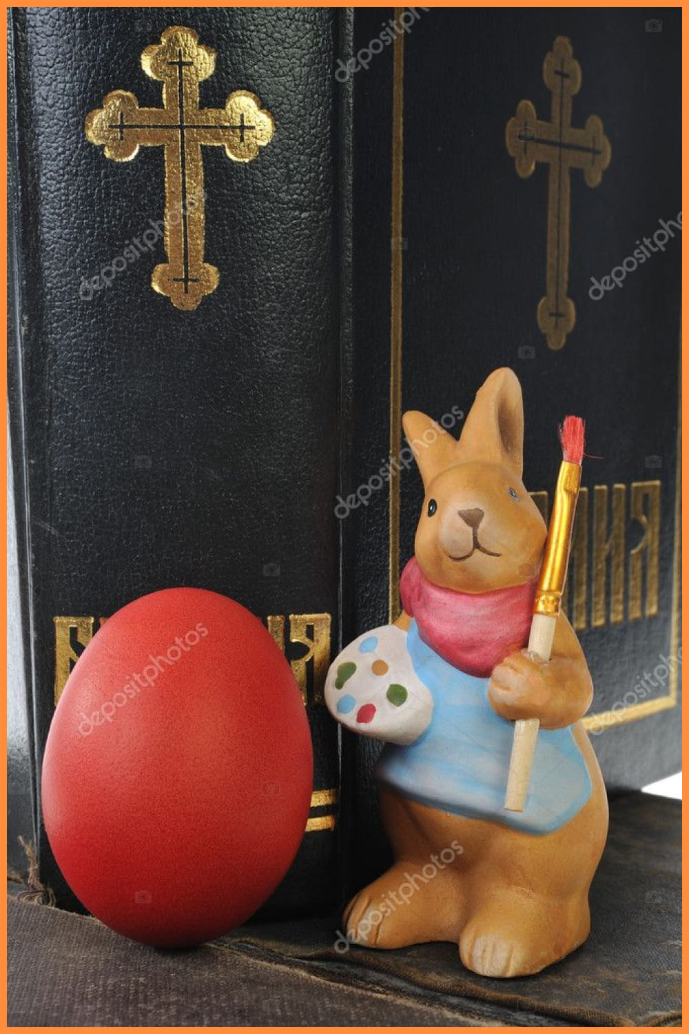 Toy rabbit with a brush and a palette near a red egg.