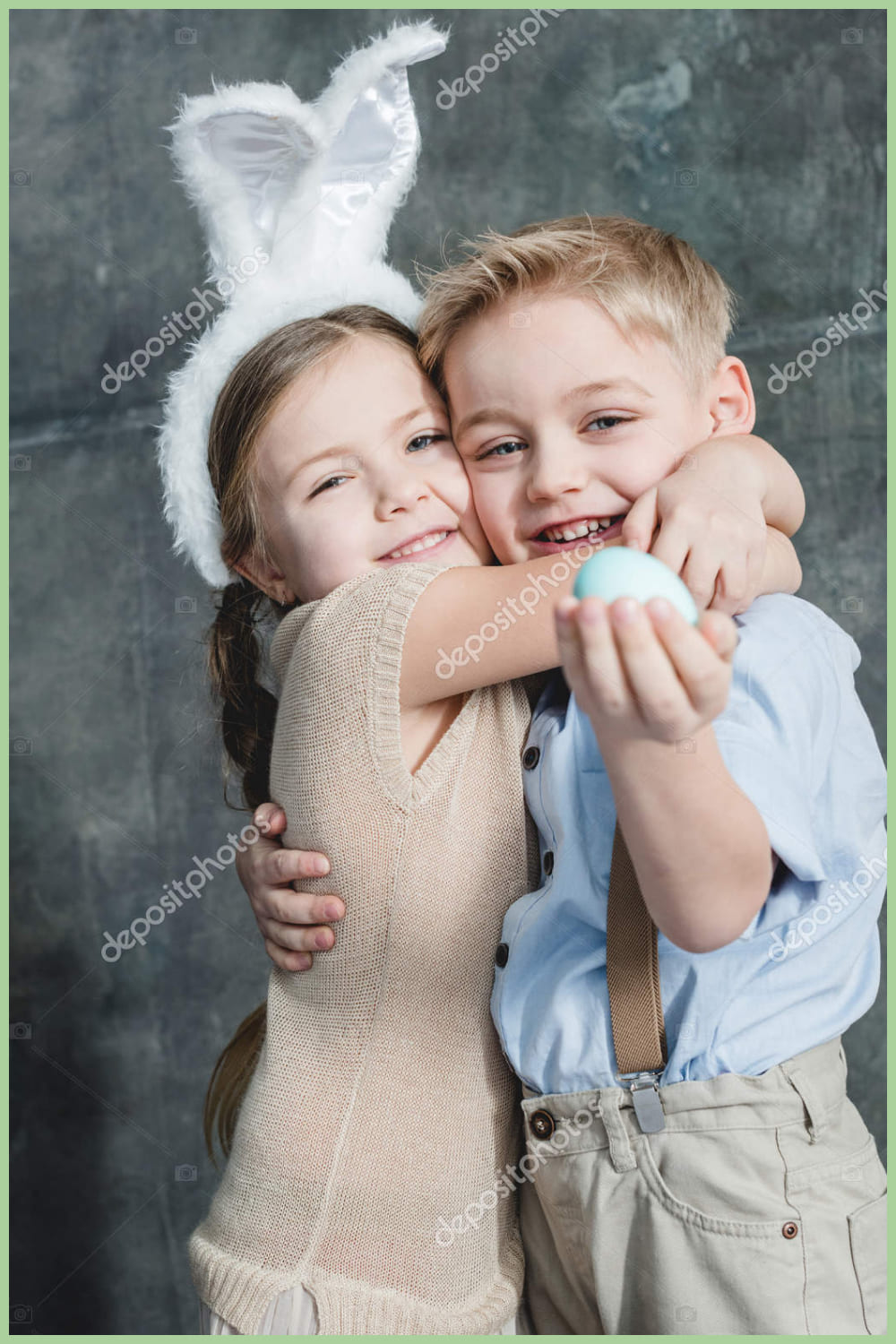 Girl and boy hugging each other and easter egg in boy's hand.