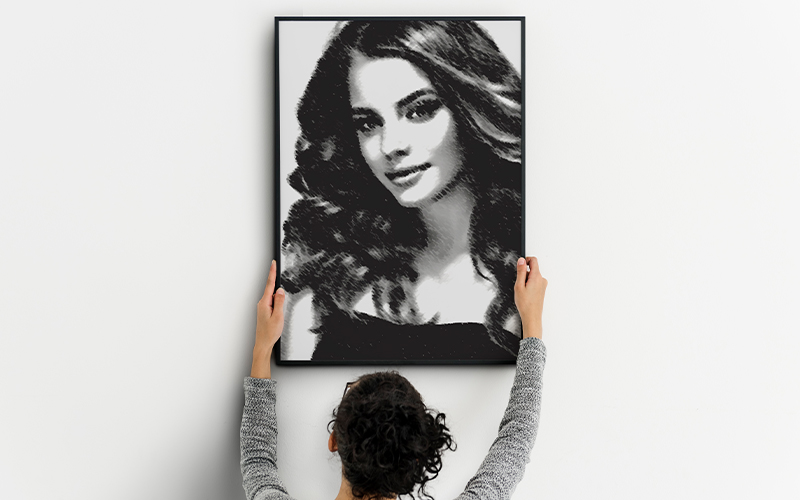 Woman holding up a black and white picture of a woman.