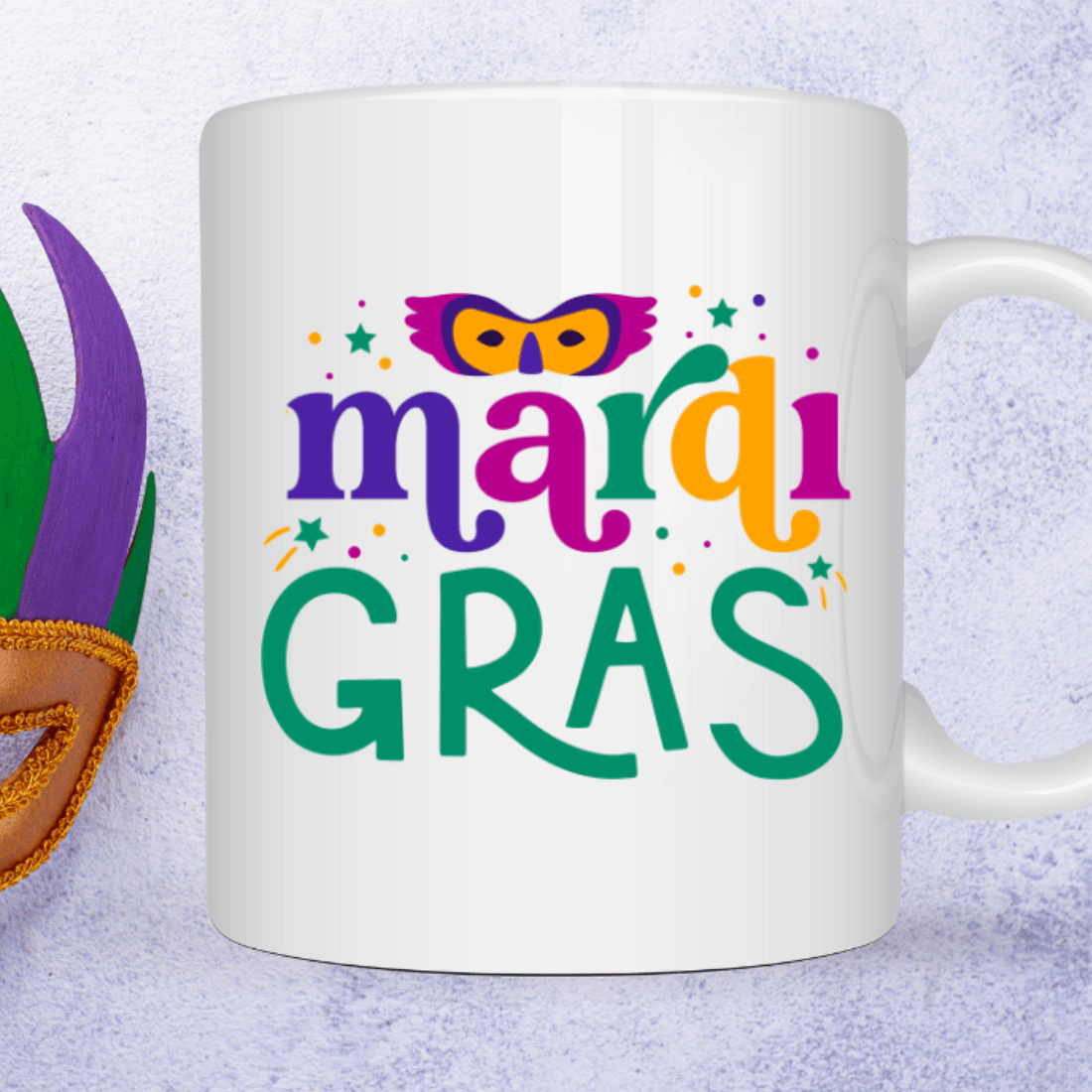 Mardi gras mug next to a mardi gras mask.