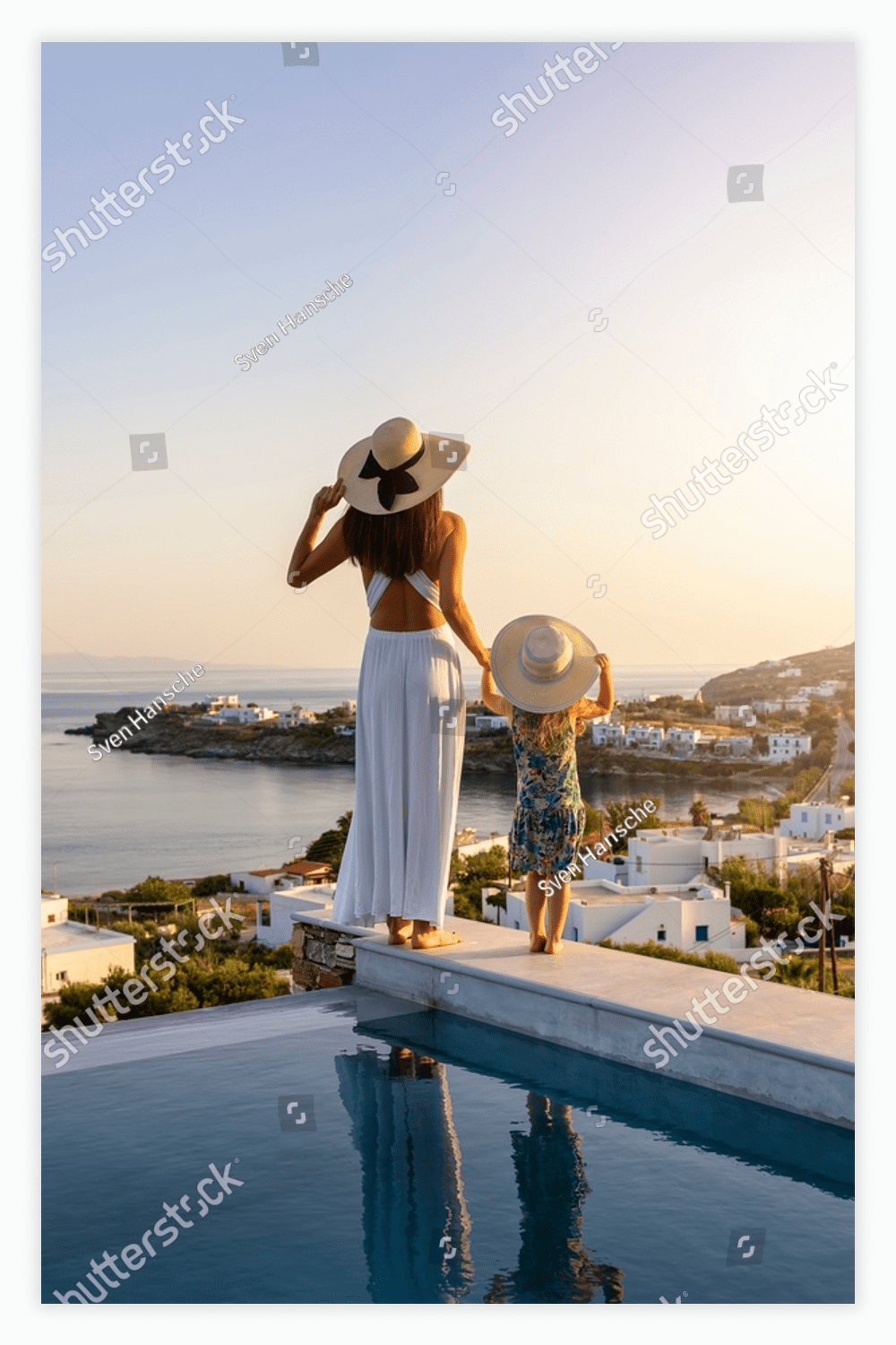 Woman and a child standing on the edge of a swimming pool.