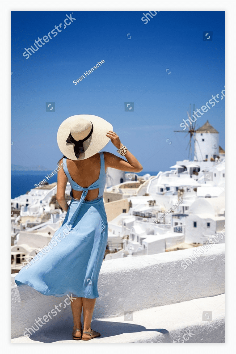 Woman in a blue dress and a white hat.