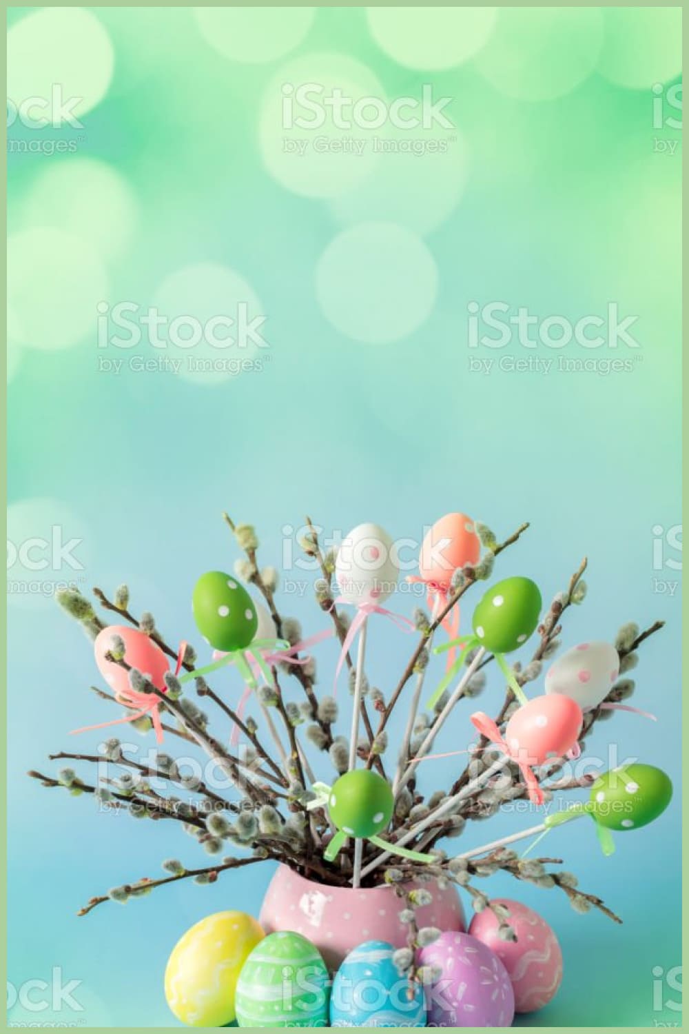 Easter eggs and pussy willow twigs with catkins in a vase stock photo.