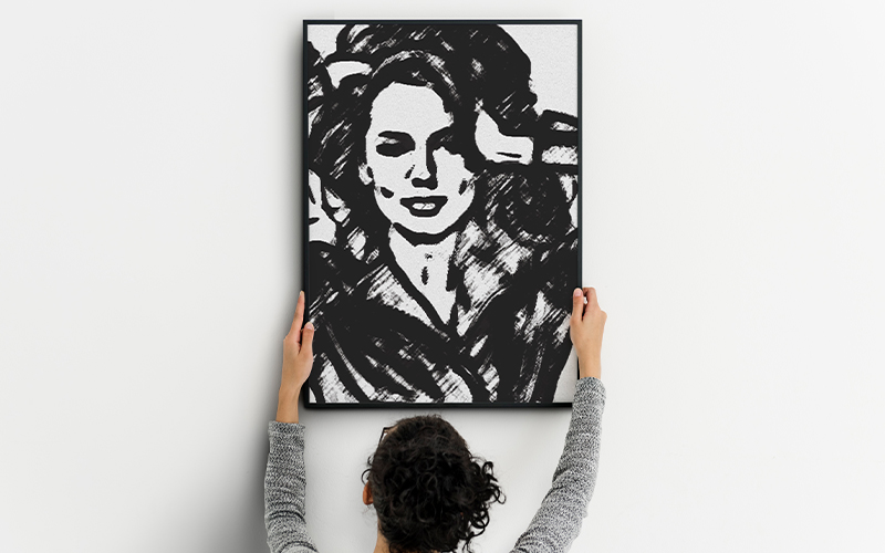 Woman holding up a black and white picture of a woman.