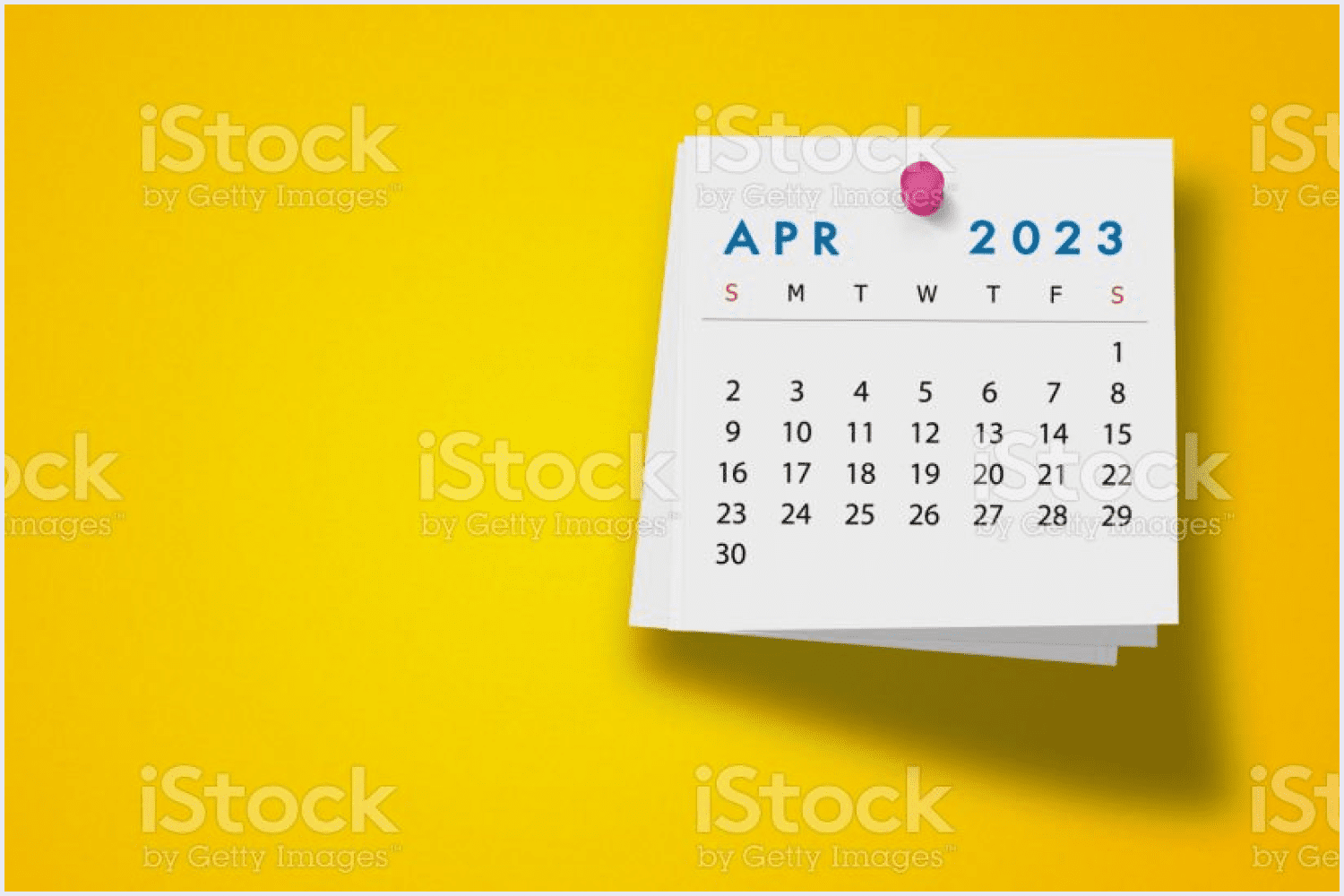 Calendar with a simple yet eye-catching design on a notepad against yellow wallpaper.