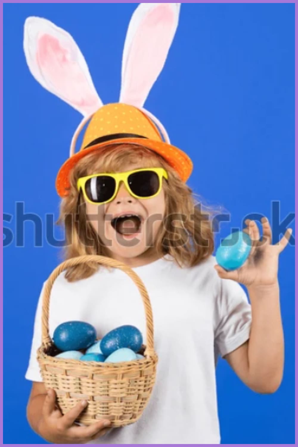 Kid boy with bunny ears hold easter basket with easter eggs.