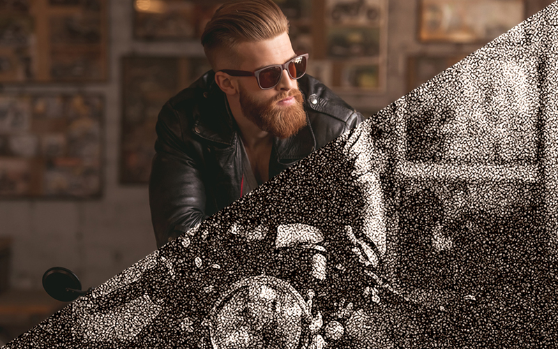 Man with a beard and sunglasses on a motorcycle.