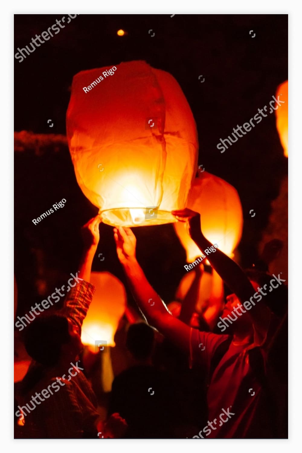 People launching flying lanterns at a festival.