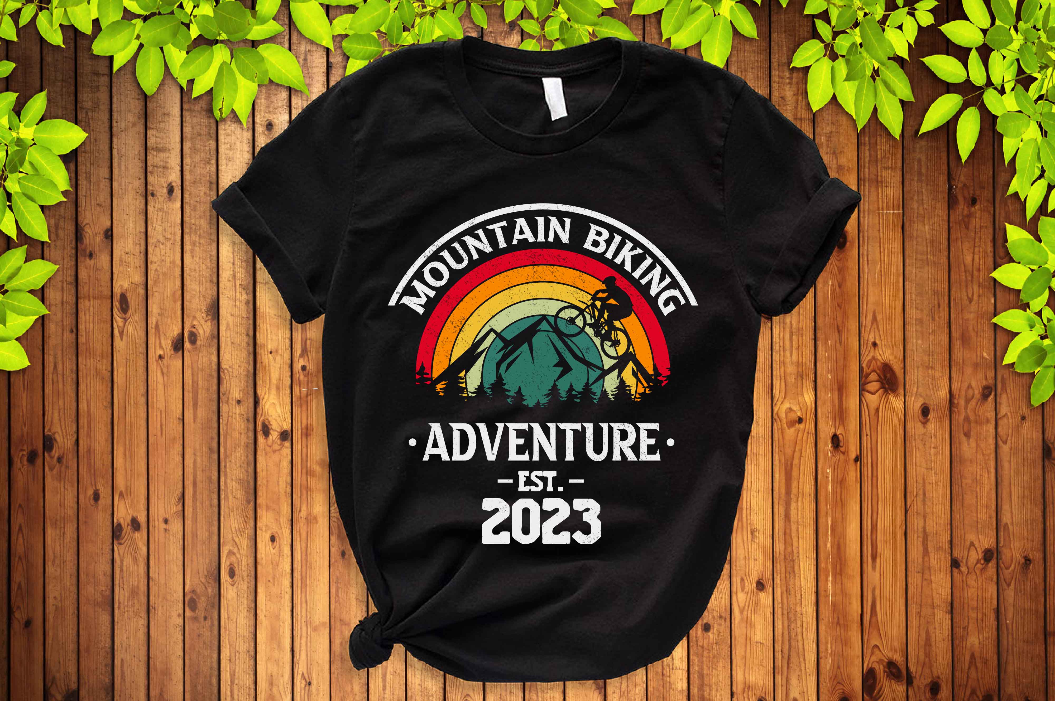 Black mountain biking adventure t - shirt on a wooden background.