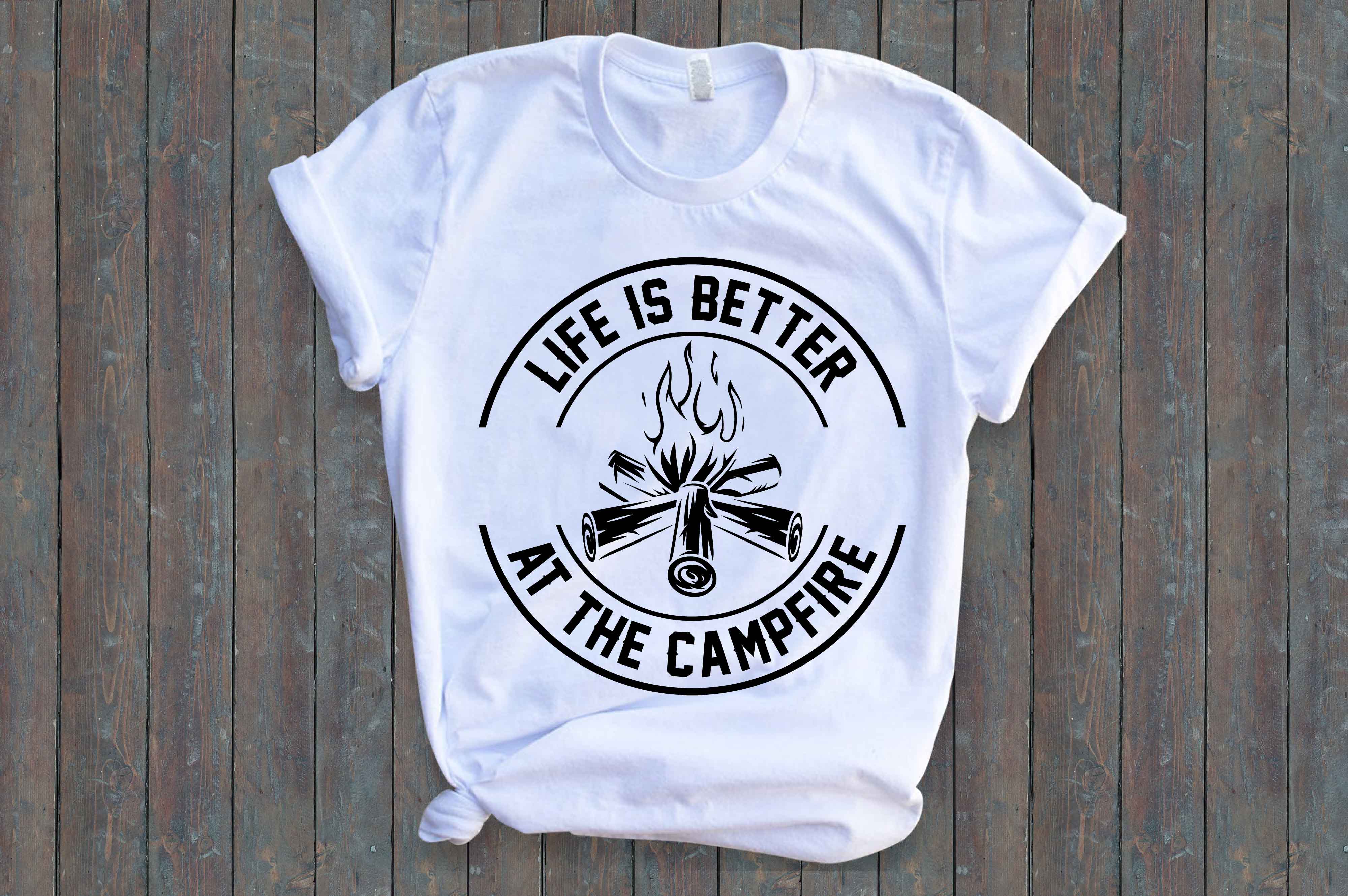 White t - shirt that says life is better at the campfire.