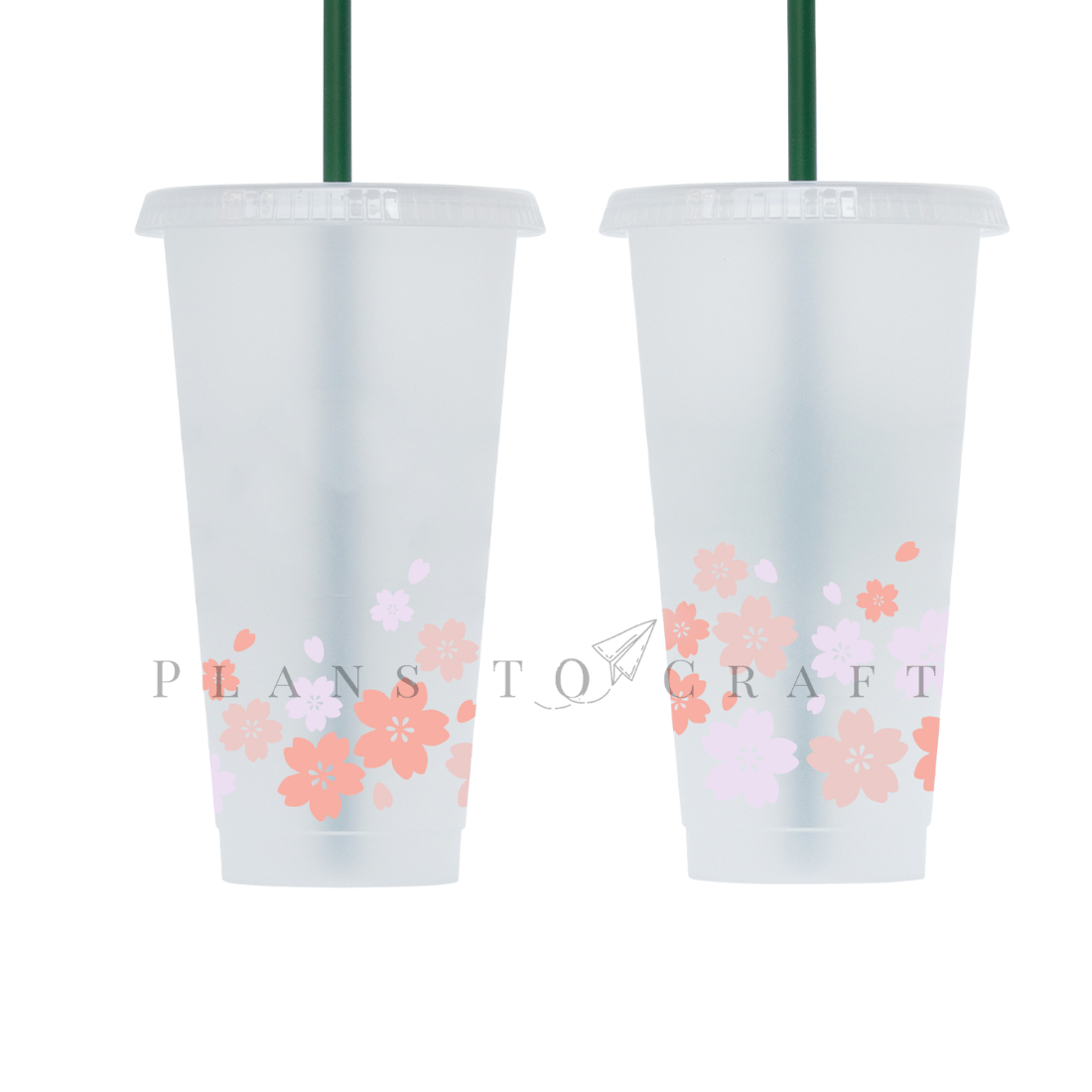 Two plastic cups with green straws and flowers on them.