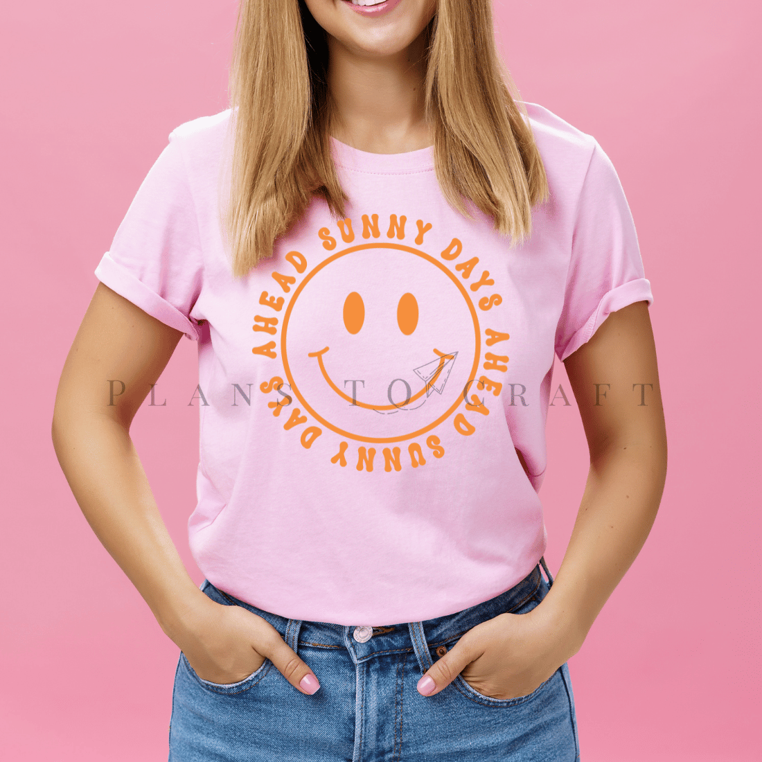 Woman wearing a pink t - shirt with a smiley face.
