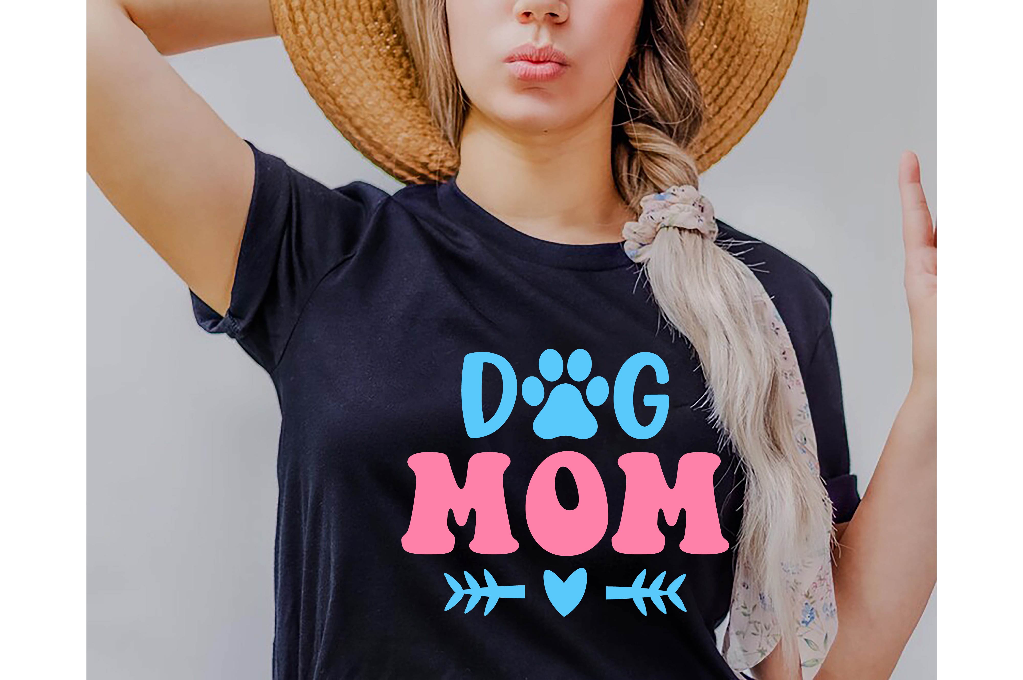 Woman wearing a dog mom shirt with a hat on her head.