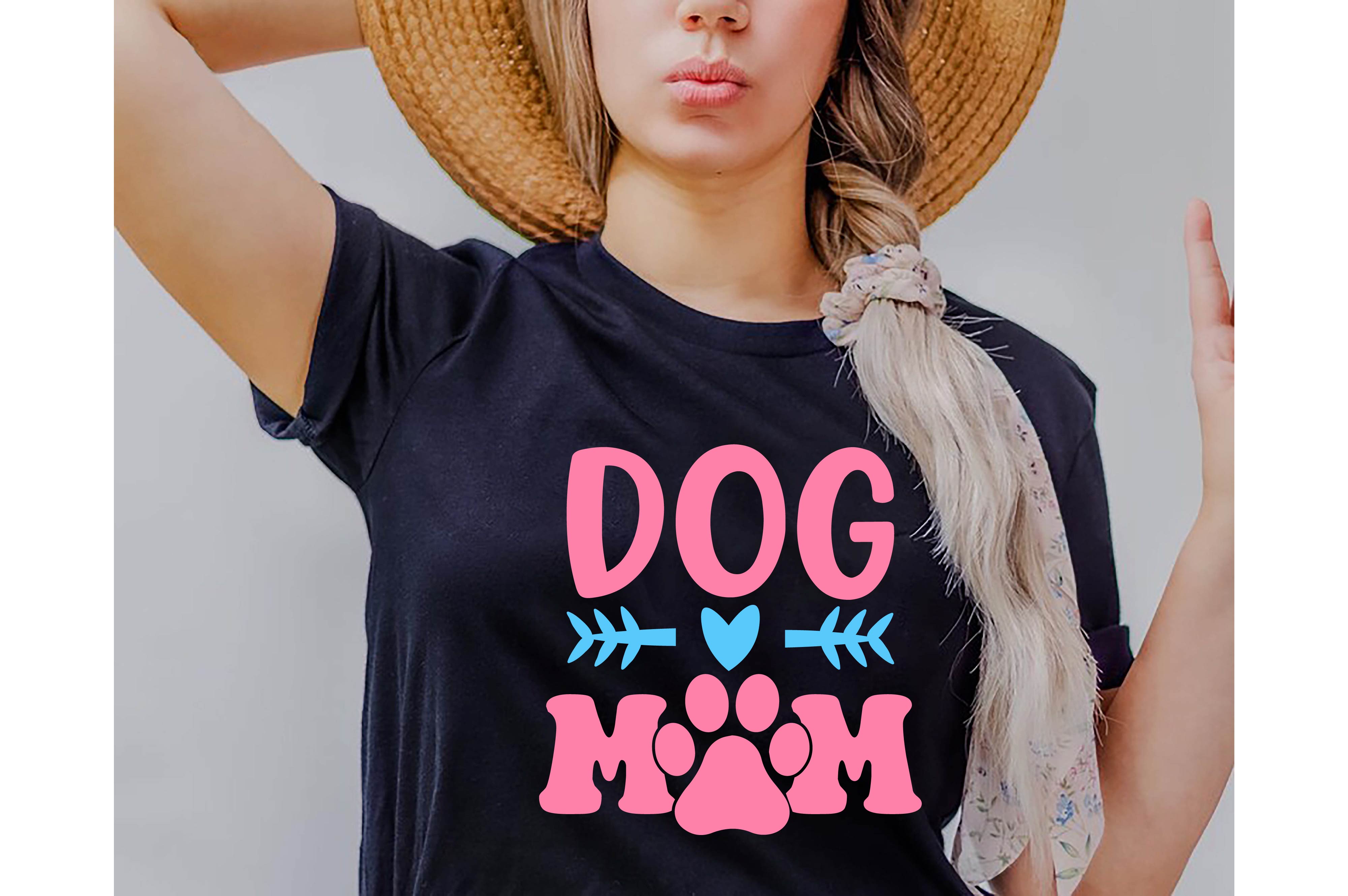 Woman wearing a dog mom shirt with a hat on her head.