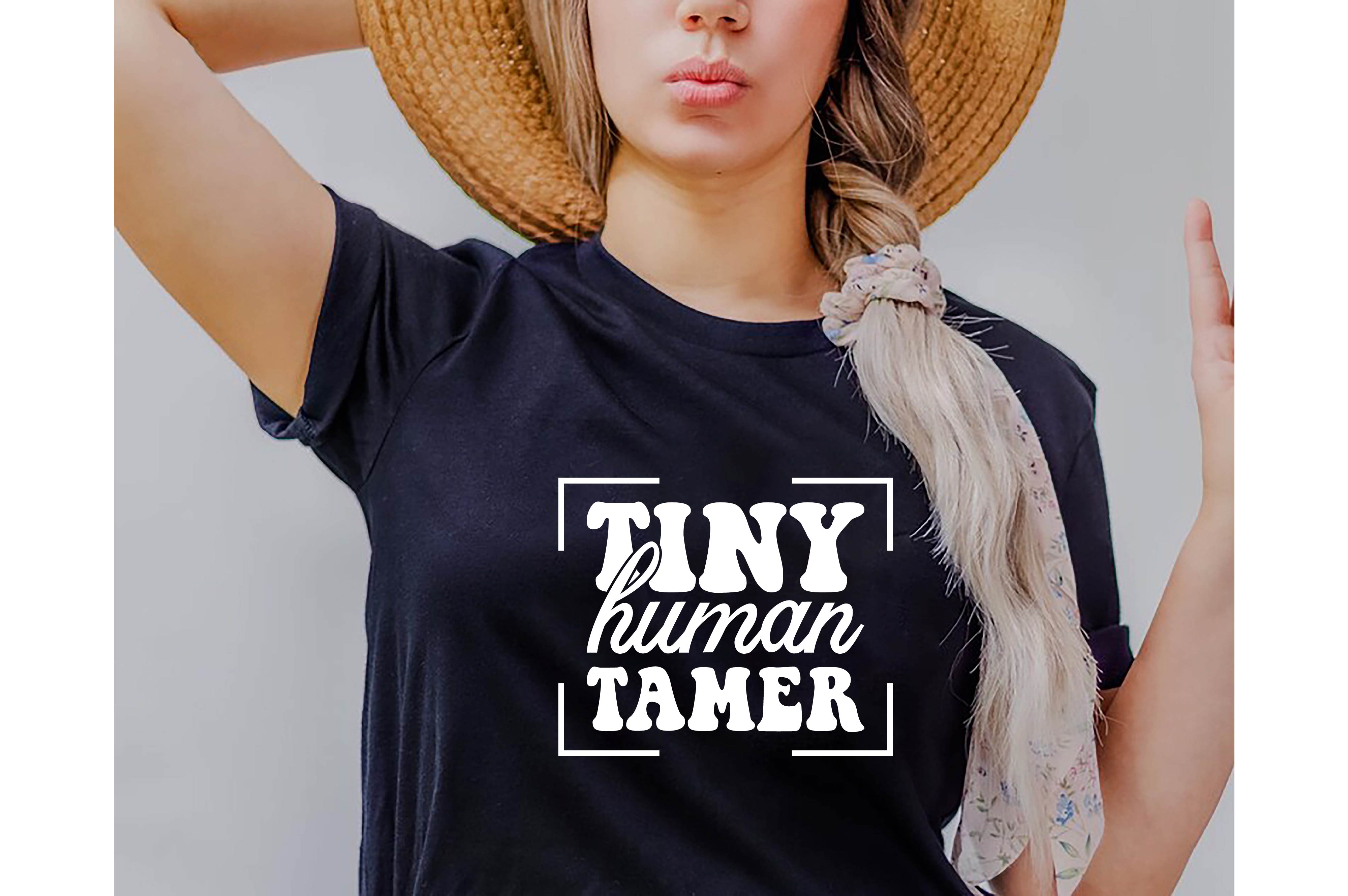 Woman wearing a hat and a t - shirt that says tiny human tamer.