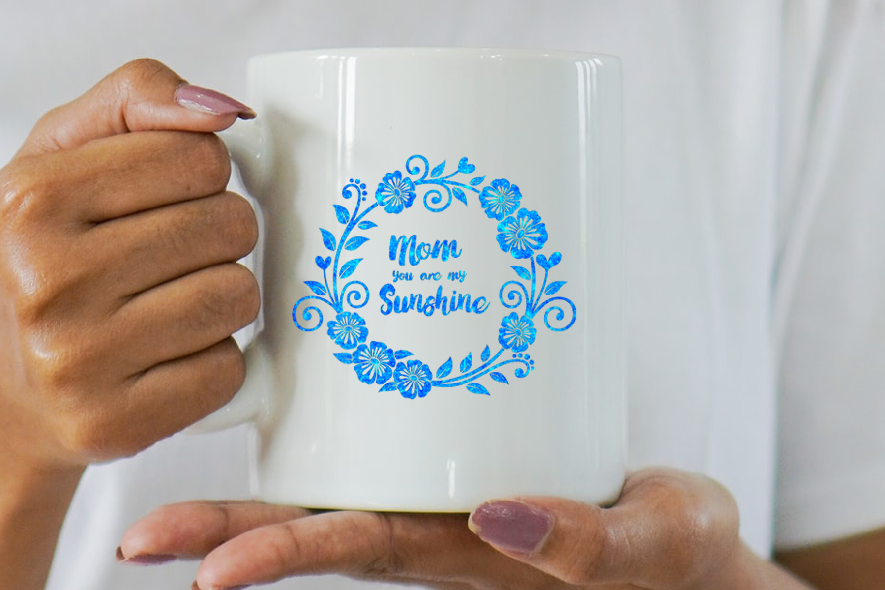 Woman holding a coffee mug with a blue floral design.
