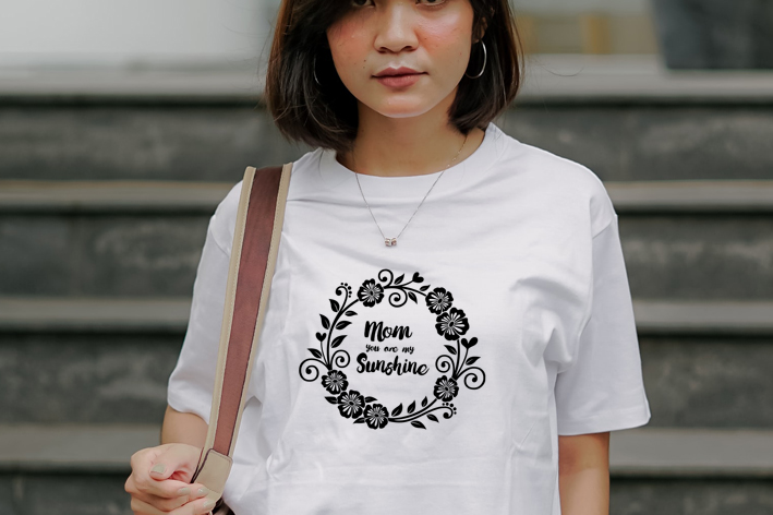 Woman wearing a t - shirt that says mom is sunshine.