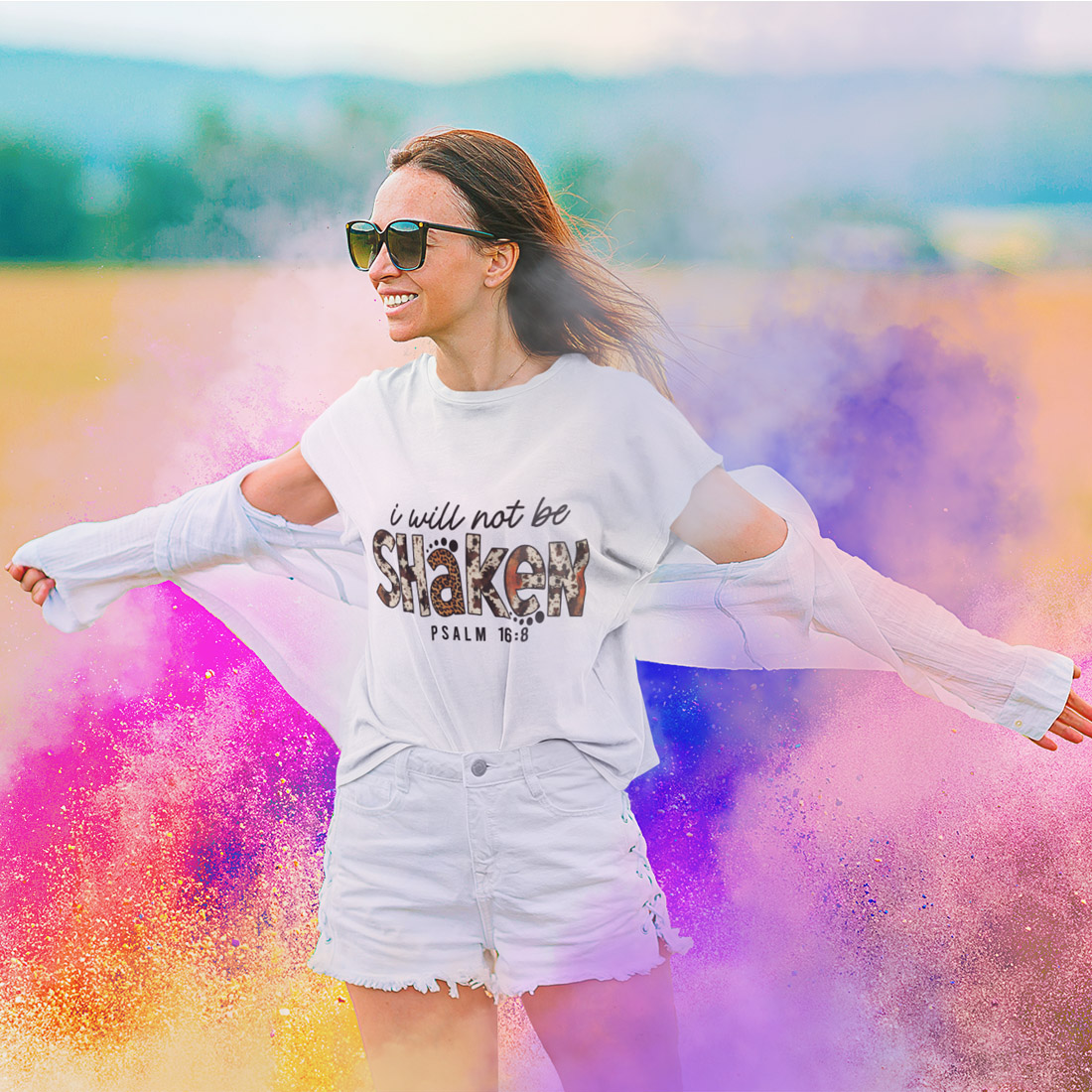 Woman in a white shirt and shorts is throwing colored powder.