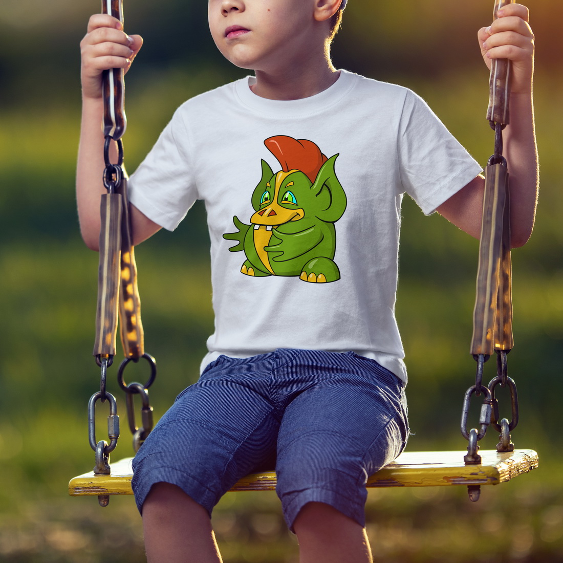 Young boy is sitting on a swing.