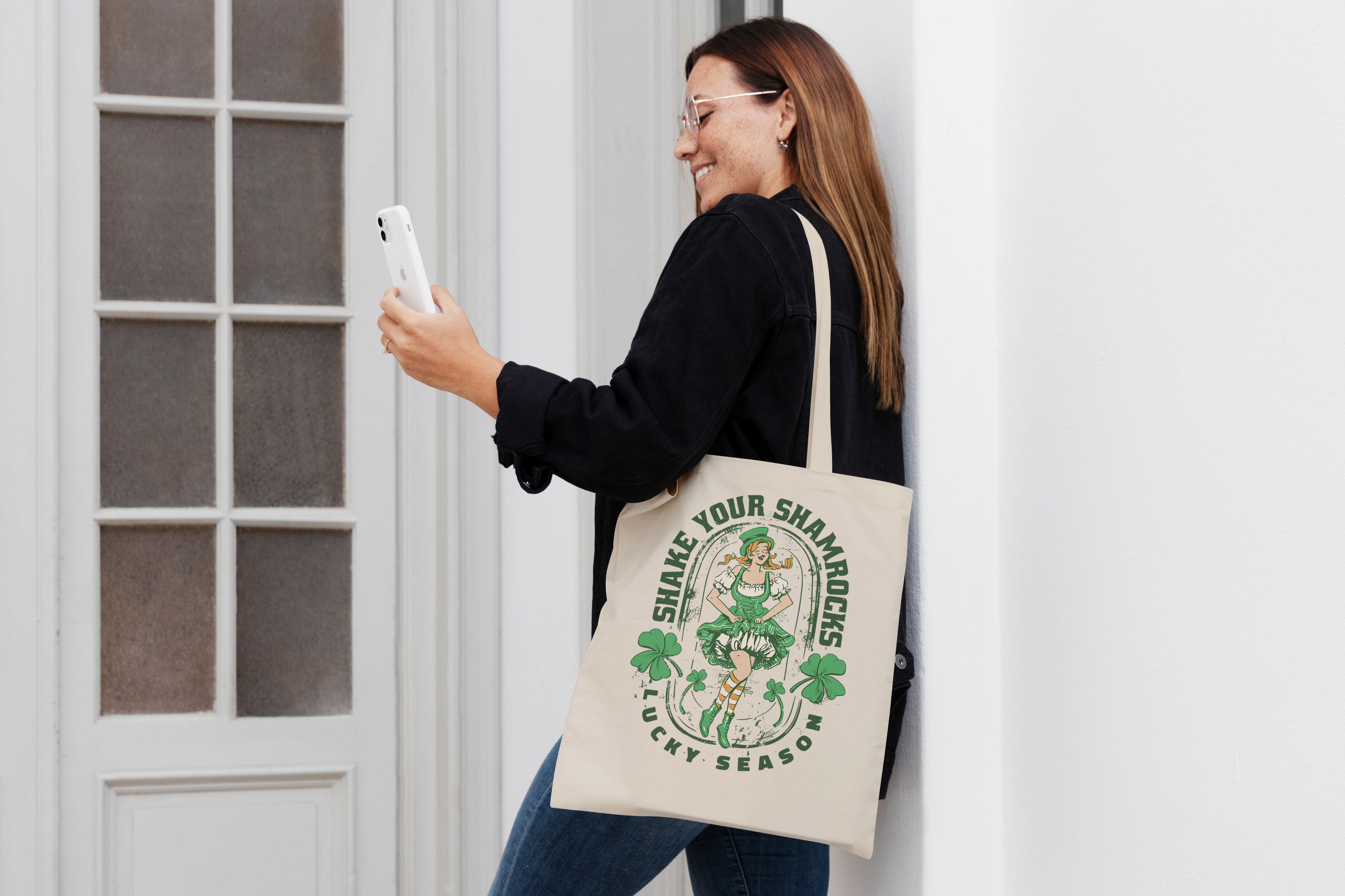 Woman holding a cell phone and wearing a st patrick's day tote.