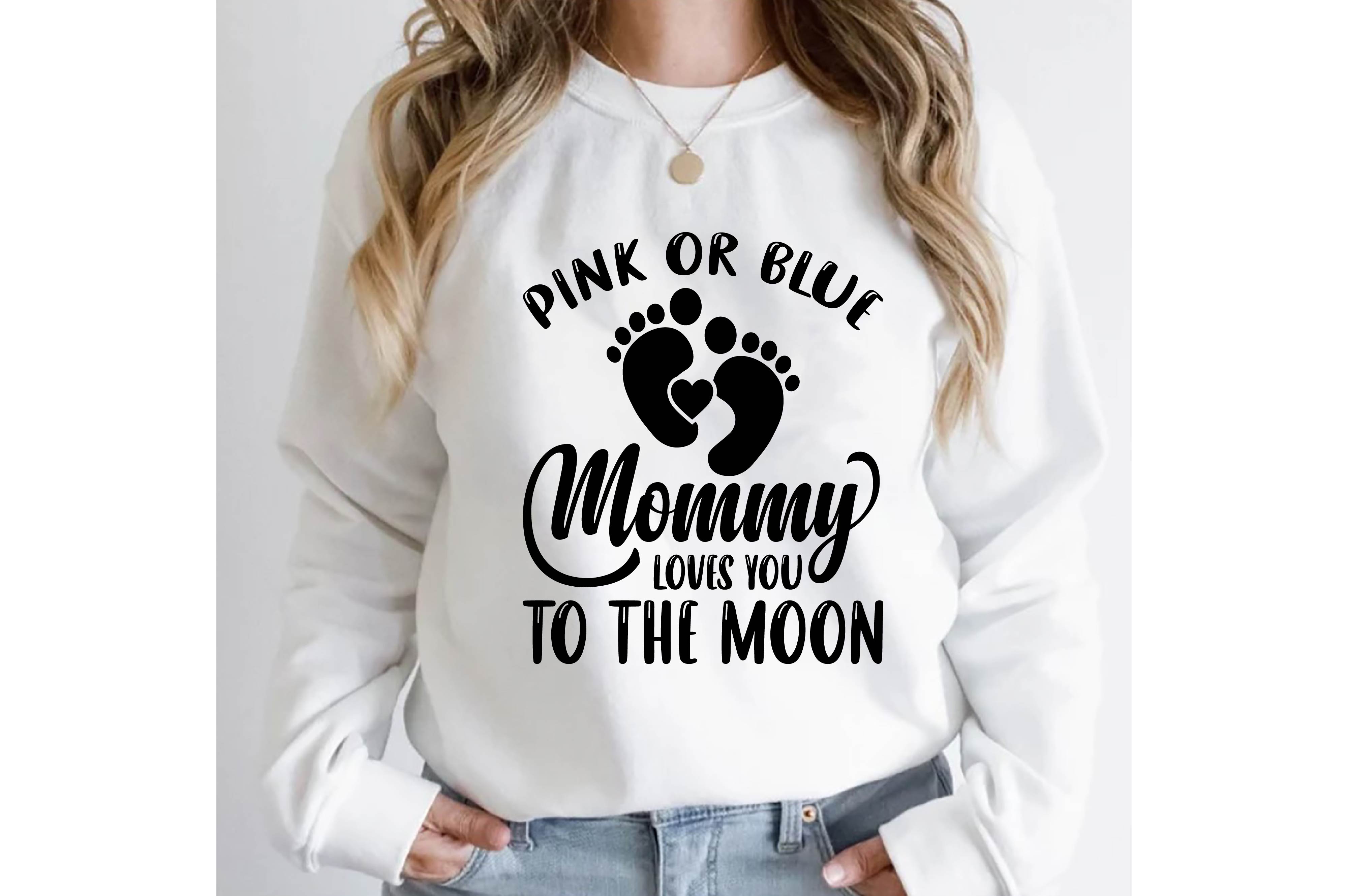 Woman wearing a sweatshirt that says pink or blue mommy to the moon.