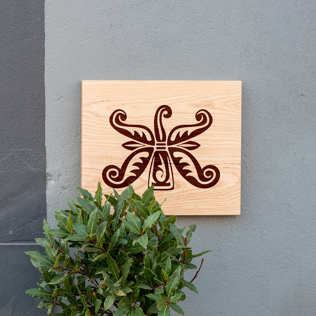 Wooden plaque with a decorative design on it.