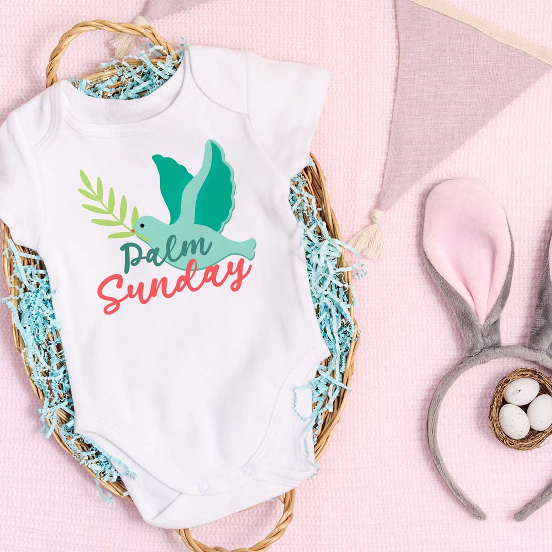 Baby's bodysuit with a bunny on it next to a pair of.