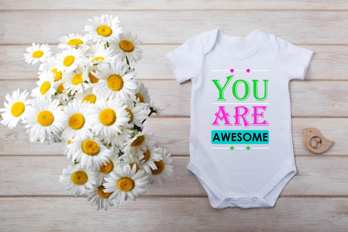 Baby bodysuit next to a bouquet of daisies.