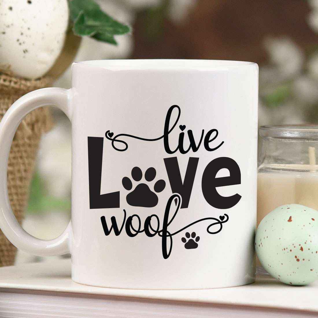 White coffee mug sitting on top of a table next to a candle.