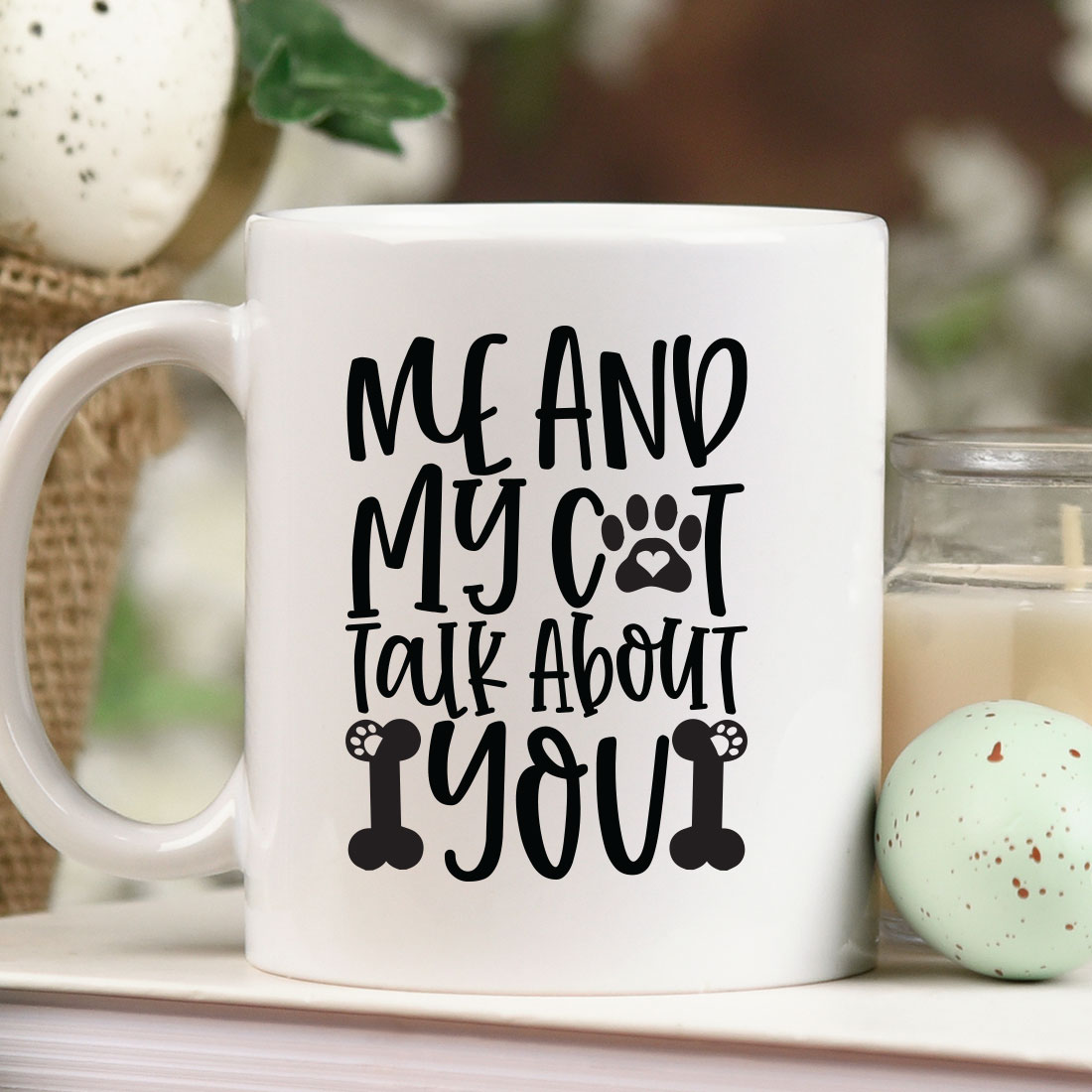 White coffee mug sitting on top of a table next to a candle.